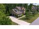 Charming two-story home showcasing a well-manicured lawn, mature trees, and a three car garage at 1820 Yates Wheel Way, Raleigh, NC 27606