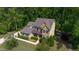 Aerial view of a charming home featuring a landscaped front yard, mature trees, and a concrete driveway at 1820 Yates Wheel Way, Raleigh, NC 27606