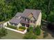 Two-story home featuring lush landscaping, green lawn, neutral colored exterior, and mature trees at 1820 Yates Wheel Way, Raleigh, NC 27606