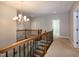 Upstairs foyer featuring detailed wrought iron railing and a decorative chandelier at 1820 Yates Wheel Way, Raleigh, NC 27606