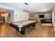 Spacious game room with a pool table, comfortable seating, and a modern lighting fixture at 1820 Yates Wheel Way, Raleigh, NC 27606