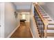 Hallway leading to the basement rec room featuring stairs with metal spindles at 1820 Yates Wheel Way, Raleigh, NC 27606