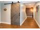 Finished hallway featuring stained concrete floors, updated lighting, and a sliding barn door at 1820 Yates Wheel Way, Raleigh, NC 27606