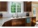 Close up of a kitchen sink, granite counter, hardwood floors and stainless steel appliances at 1820 Yates Wheel Way, Raleigh, NC 27606
