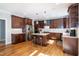Bright kitchen featuring dark wood cabinets, stainless steel appliances, granite countertops, and hardwood floors at 1820 Yates Wheel Way, Raleigh, NC 27606