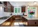 Well-lit kitchen with stainless appliances, granite counters, an island, hardwood floors, and a large window at 1820 Yates Wheel Way, Raleigh, NC 27606