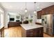 The kitchen opens to the living room and features dark wood cabinetry, stainless steel appliances, and granite countertops at 1820 Yates Wheel Way, Raleigh, NC 27606