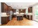Spacious kitchen features dark wood cabinetry, stainless steel appliances, granite countertops, and hardwood floors at 1820 Yates Wheel Way, Raleigh, NC 27606