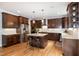 Spacious kitchen features dark wood cabinetry, stainless steel appliances, granite countertops, and hardwood floors at 1820 Yates Wheel Way, Raleigh, NC 27606