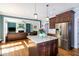 Kitchen featuring stainless steel appliances, hardwood floors, a center island, and a view to the living room at 1820 Yates Wheel Way, Raleigh, NC 27606
