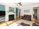 Living room showcasing a fireplace with white mantle, hardwood floors, and comfortable brown leather furniture at 1820 Yates Wheel Way, Raleigh, NC 27606