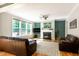 Bright living room featuring a fireplace, large windows, hardwood floors, and comfortable brown leather furniture at 1820 Yates Wheel Way, Raleigh, NC 27606