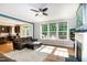Living room featuring hardwood floors, a ceiling fan, a fireplace, and a wall of windows at 1820 Yates Wheel Way, Raleigh, NC 27606