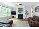 Comfortable living room with fireplace, hardwood floors, and large windows at 1820 Yates Wheel Way, Raleigh, NC 27606