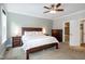 Main bedroom with a ceiling fan, stylish furnishings, and an open doorway to the ensuite bathroom at 1820 Yates Wheel Way, Raleigh, NC 27606