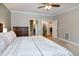Bright main bedroom with a ceiling fan and neutral walls, offering doorways to the ensuite and walk-in closet at 1820 Yates Wheel Way, Raleigh, NC 27606