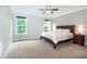 Spacious main bedroom with a ceiling fan, neutral tones, and natural light from the double window at 1820 Yates Wheel Way, Raleigh, NC 27606