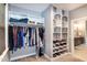 Walk-in closet featuring custom built-in shelving and hanging rods with lots of storage, plus an open bathroom view at 1820 Yates Wheel Way, Raleigh, NC 27606