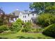 Landscaped backyard with lush greenery and a charming two-story home, perfect for outdoor relaxation at 19 Oak Dr, Durham, NC 27707