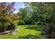 Sprawling backyard with lush greenery and a variety of trees and shrubs at 19 Oak Dr, Durham, NC 27707