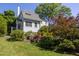 View of the home's exterior from the landscaped backyard, showcasing a garden and mature trees at 19 Oak Dr, Durham, NC 27707