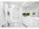 Well-lit white bathroom featuring a skylight, a shower-tub combo, and white cabinets at 19 Oak Dr, Durham, NC 27707