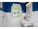Bright bathroom with a white vanity, fresh flowers, and a decorative window overlooking the manicured landscaping at 19 Oak Dr, Durham, NC 27707