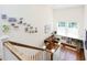 Upstairs hallway with photos on the wall, hardwood floors, a bookcase, and a large window at 19 Oak Dr, Durham, NC 27707