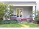 Relaxing porch area with comfortable seating, barrel planters with colorful flowers, and a stone pathway at 19 Oak Dr, Durham, NC 27707