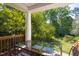 Charming outdoor porch with a glass table and chairs, surrounded by lush greenery and natural light at 19 Oak Dr, Durham, NC 27707