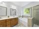 Bright bathroom featuring a soaking tub with a window, and a walk-in shower with decorative tile at 20 Paddy Ln, Youngsville, NC 27596