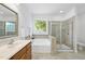 Bright bathroom featuring a soaking tub with a window, and a walk-in shower with decorative tile at 20 Paddy Ln, Youngsville, NC 27596