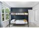 Bedroom featuring a black metal bunk bed, a window, and a dark blue accent wall at 20 Paddy Ln, Youngsville, NC 27596