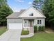 Charming home featuring a well-maintained lawn, attached garage, and inviting covered front porch with wood stairs at 20 Paddy Ln, Youngsville, NC 27596