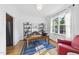 Bright office with a large window, a blue rug, and built-in shelves with many books at 20 Paddy Ln, Youngsville, NC 27596