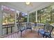 Screened porch featuring wood flooring, three chairs, and views of trees at 20 Paddy Ln, Youngsville, NC 27596