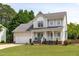 Two-story home with garage and covered front porch, landscaped yard and mature trees at 2013 Waterton Ln, Apex, NC 27502