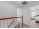 Upstairs hallway with carpet flooring, wood railing and leads to bedrooms at 2013 Waterton Ln, Apex, NC 27502