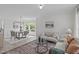 Bright living room featuring light-colored walls, a decorative rug, and a dining area with modern chandelier at 2013 Waterton Ln, Apex, NC 27502