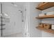 Large glass shower with modern fixtures and built-in shelving and wood shelving at 2013 Waterton Ln, Apex, NC 27502