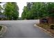 Community entrance with a brick Windbrooke sign surrounded by lush trees near playground at 205 Windbyrne Dr, Cary, NC 27513