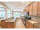 Kitchen with stainless steel appliances, brown cabinets, and adjacent breakfast nook with big windows at 216 Beringer Pl, Chapel Hill, NC 27516