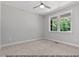 Carpeted bedroom features a ceiling fan and a large window offering exterior views at 249 Rawhide Dr, Louisburg, NC 27549