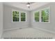 This bedroom features a ceiling fan, large windows, neutral colors and plush carpet flooring at 249 Rawhide Dr, Louisburg, NC 27549