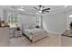 Neutral bedroom with a tray ceiling, carpet, two windows, and side tables with lamps at 249 Rawhide Dr, Louisburg, NC 27549