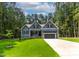 Charming blue home with a two car garage and a well manicured green lawn at 249 Rawhide Dr, Louisburg, NC 27549