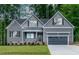 Charming home with gray siding, black shutters, inviting front porch, and well-manicured lawn at 249 Rawhide Dr, Louisburg, NC 27549