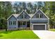Charming home with blue siding, black shutters, a two car garage, and a well manicured green lawn at 249 Rawhide Dr, Louisburg, NC 27549