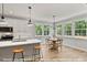 Bright kitchen with white cabinets, stainless appliances, island with bar stools, and dining space at 249 Rawhide Dr, Louisburg, NC 27549