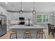 Bright kitchen with white cabinets, stainless steel appliances, and a large center island with seating at 249 Rawhide Dr, Louisburg, NC 27549
